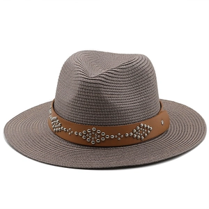 Detailed weave of fedora straw hat with brown leather band and silver rivet accents