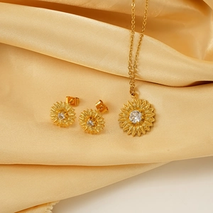 Elegant gold sunflower jewelry set with sparkling crystals on premium silk fabric