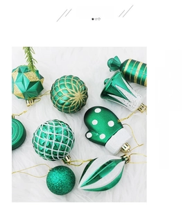Detail of forest green, white and gold Christmas ornaments on white faux fur background