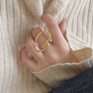 Minimalist double-layered gold geometric open ring shown on a finger with knitwear