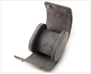 Detail of single gray leather watch roll with snap closure and soft interior cushion