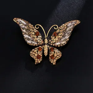 Elegant butterfly brooch in gold-tone alloy with amber rhinestones and clear crystals