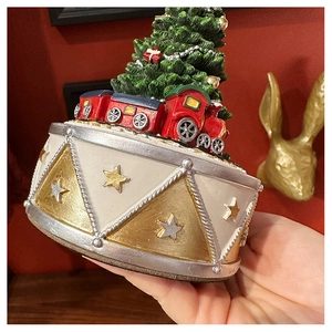 Detailed close-up of a Christmas tree music box base with a colorful toy train
