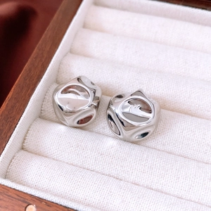 Macro shot of silver stud earrings with liquid lava texture in a velvet jewelry box