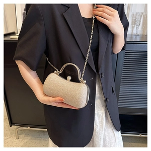 Detail of champagne gold glitter evening bag with elegant metal handle and chain strap