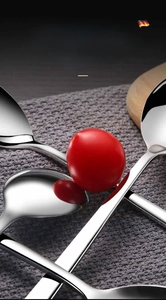 Macro detail of polished stainless steel spoons with mirror finish on grey fabric