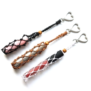 Detail of hand-woven mesh lipstick holders in black, brown, and white with heart buckles