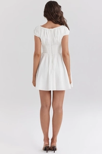 Détail de mini robe blanche à manches bouffantes, fermeture éclair et taille corsetée