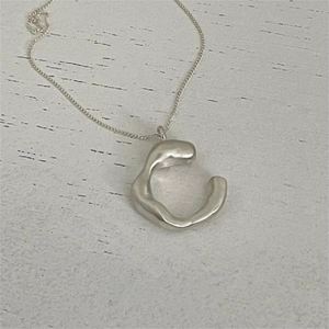 Macro detail of irregular S925 sterling silver ring pendant with textured finish