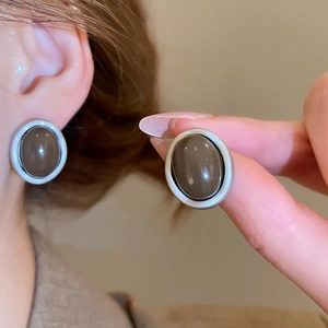 Detail of dark brown leopard acrylic oval earring with matte silver border