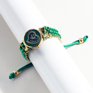 Detail of heart-shaped green dial watch with rhinestone scales and woven bracelet band