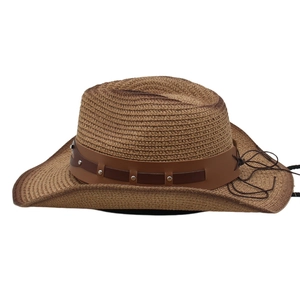 Detail of a wide brim straw cowboy hat with a studded leather band and side string