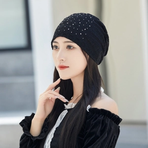 Detail of black lace slouchy beanie featuring sparkling rhinestones and hollow-out texture