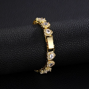 Dettaglio del bracciale dorato con maglie a cuore e zirconi su espositore nero