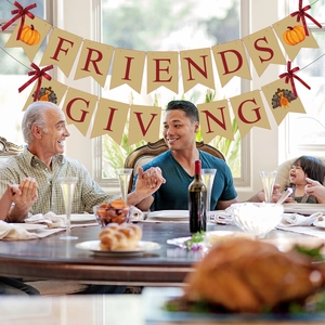 Burlap Friendsgiving banner with pumpkin turkey designs and red bows for party decor