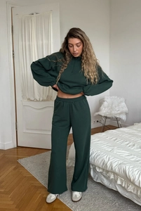 Detail of dark green tracksuit featuring a half-zip sweatshirt and wide-leg trousers