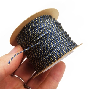 Detailed view of 1mm blue and gold twisted cord on a paper spool for DIY jewelry