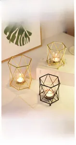 Detail of geometric metal candle holders in gold and black with glass inserts