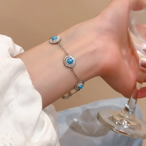 Détail d'un bracelet en argent avec pierres turquoises et diamants porté au poignet