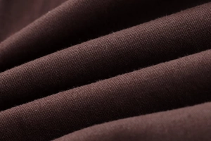 Macro trama del tessuto twill marrone scuro che mostra fibre dettagliate e pieghe diagonali