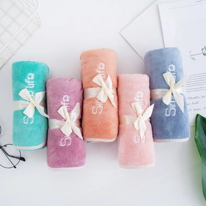 Close-up of soft coral fleece towels in five vibrant colors with simple embroidery