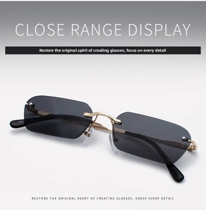 Macro detail of rimless rectangle sunglasses with grey lenses and gold metal temples