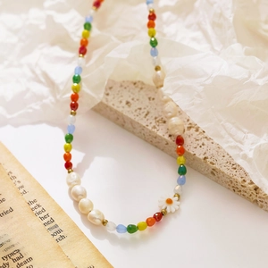 Detail of colorful seed bead necklace with white daisy pendant and pearl accents