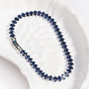 Detailed close-up of dark blue marquise zircon tennis bracelet with silver metal base