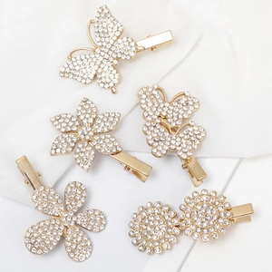 5Pcs gold rhinestone duckbill hair clips with butterfly and flower designs on white cloth