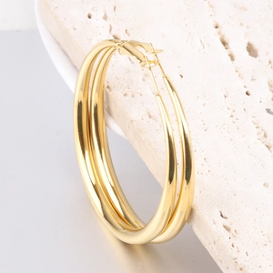 Polished 6mm gold-tone water drop hoop earrings displayed on a textured stone prop