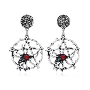 Détail macro de boucles d'oreilles toile d'araignée argentées avec strass rouges
