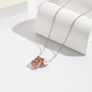 Minimalist necklace with orange zircon and white pearl pendant on silver chain