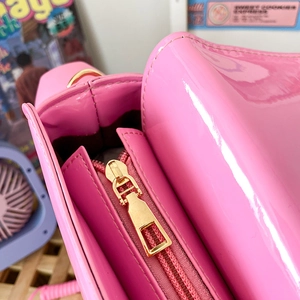Detail of pink patent leather handbag with gold zipper and premium stitching quality