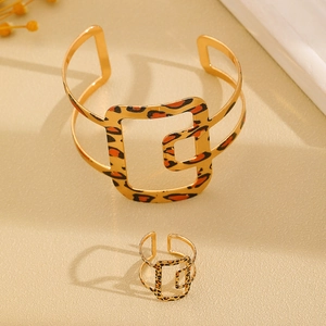 Detalle del conjunto de brazalete y anillo ajustable con diseño geométrico de leopardo