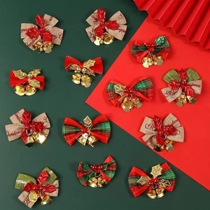 Christmas bow hangers with bells and berries on dark green background
