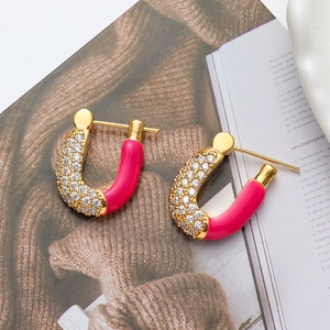 U-shaped gold earrings with red and white enamel accents and sparkling cubic zirconia