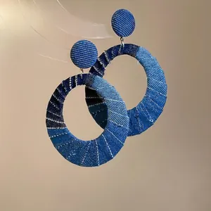 Denim fabric wrapped oval hollow hoop earrings with patchwork blue textures and silver needle