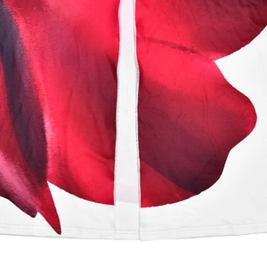 Detail shot of vibrant red floral rose print on white fabric with vertical stitching