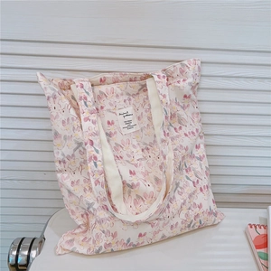 Detail of floral canvas tote bag with bunny prints and reinforced white straps
