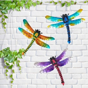 Detailed view of colorful metal dragonflies on a white brick wall for home wall decor