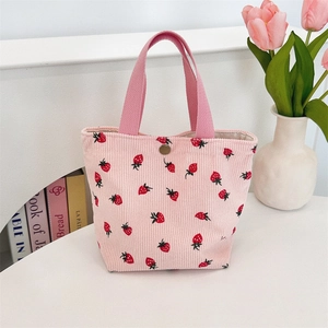 Détail du sac cabas en velours côtelé rose avec imprimé fraise et bouton pression métal