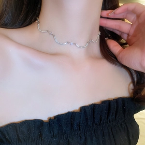 Dettaglio del girocollo argentato ondulato con zirconi brillanti indossato da modella