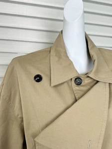 Close-up detail of khaki trench coat collar with black resin buttons and twill fabric texture