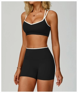 Detail shot of black sports bra with white trim and cross-back straps on model