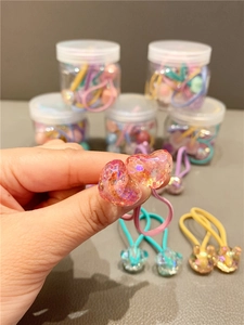 Detail of pink heart resin hair ties with assorted candy color elastic bands in jars