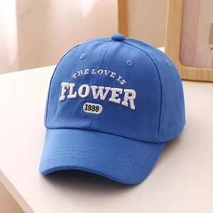 Gros plan détaillé de la casquette bleue en coton avec broderie blanche en relief