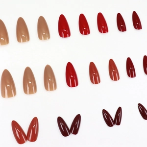 Glossy almond press-on nails in nude, red, and burgundy tones set on white background