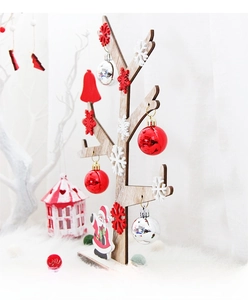 Detail of wooden DIY Christmas tree with red ornaments and white snowflakes on plush rug