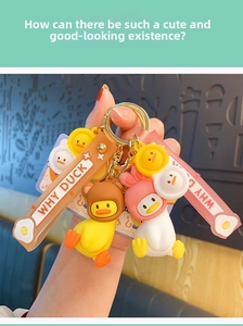 Gros plan de porte-clés canard jaune et blanc avec bonnets en peluche et lanières souples