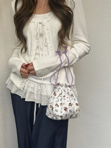 Close-up of quilted cartoon storage bag with purple drawstring handles held by a model